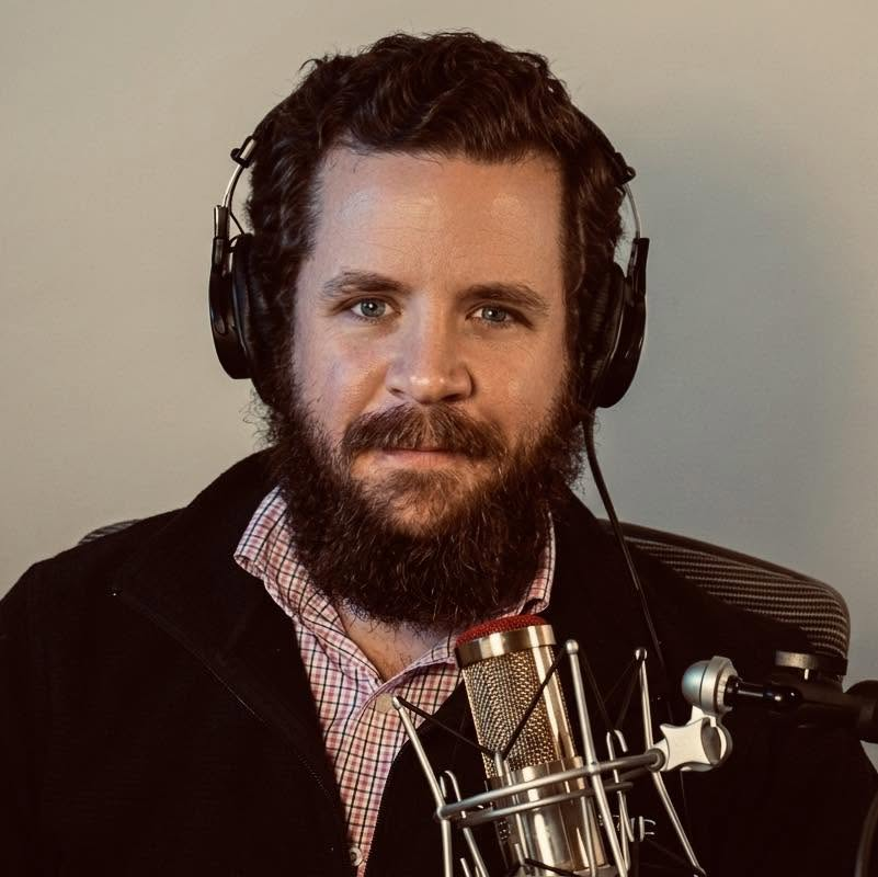 Joshua Goode wearing headphones at a microphone